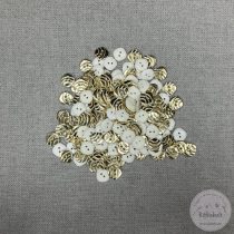   Hátán fehér, színén csillogó arany, csíkos, két lyukú