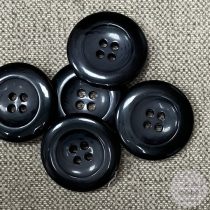 Szürke-fekete, négy lyukú kabátgomb