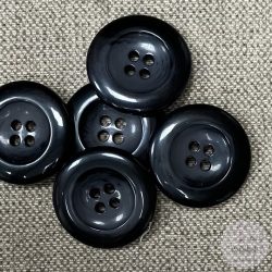 Szürke-fekete, négy lyukú kabátgomb