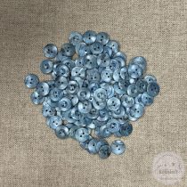 Acélkék, két lyukú, gomblyuk körül bemélyedés