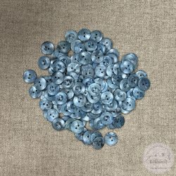 Acélkék, két lyukú, gomblyuk körül bemélyedés